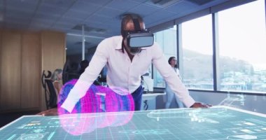 VR kulaklık takan bir iş adamının animasyonu. Masada 3D planı var.