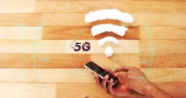 Covid 19 hücre ve 5G metin animasyonu kablosuz internet sembolü üzerinden tarama ve arka planda akıllı telefon kullanan kişi. Dijital olarak üretilen küresel koronavirüs pandemik konsepti.