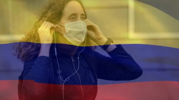 コロンビアの国旗が顔のマスクをした白人女性に手を振ってイヤフォンをつけたアニメーション Covid 19コロナウイルス国家安全コンセプトデジタル複合体 — ストック動画
