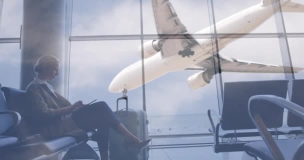 Animación Del Avión Volando Sobre Una Pasajera Usando Tableta Digital — Vídeos de Stock