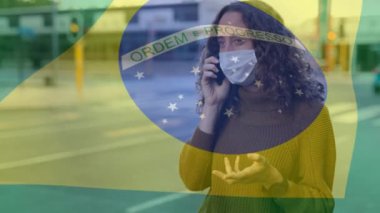Brezilya bayrağının yüz maskesi takan, telefonda konuşan bir kadının üzerinde dalgalanması. Covid-19 Coronavirus Ulusal Sağlık Güvenliği Konsepti Dijital Kompozit