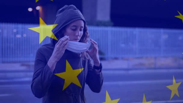 在拿着面具的白人妇女面前挥动欧盟旗帜的动画 Covid Coronavirus国家健康安全概念数字复合材料 — 图库视频影像