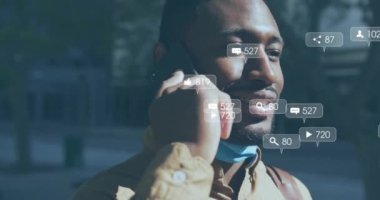 Mutlu Afro-Amerikan bir adamın akıllı telefondan konuşması üzerine sosyal medya bildirimleri. Dijital arayüz, bağlantı, sosyal ağ, yaşam tarzı ve iletişim, dijital olarak oluşturulmuş video.