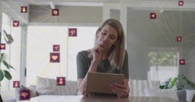 Tablet kullanan beyaz kadın üzerindeki simgelerle bağlantı ağının animasyonu. Sosyal medya ve dijital arayüz konsepti dijital olarak oluşturulmuş video.