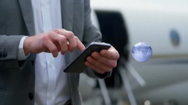 Kafkas iş adamının havaalanında akıllı telefon kullanarak dünyayı döndürmesinin animasyonu. Küresel iş ve dijital arayüz kavramı dijital olarak oluşturulmuş video.