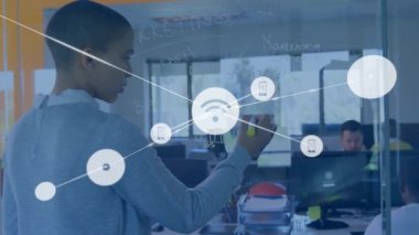 Çift ırklı iş kadınlarının not almasıyla ilgili simgelerle olan bağlantıların animasyonu. Küresel iş, teknoloji ve dijital arayüz kavramı dijital olarak oluşturulmuş video.