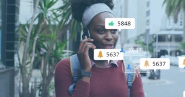 Şehirde akıllı telefondan konuşan Afro-Amerikan bir kadın hakkında medya bildirimleri. Yaz, yaşam tarzı, şehir, dijital arayüz, sosyal ağ ve iletişim, dijital olarak oluşturulmuş video.