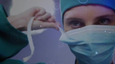 Ameliyat sırasında beyaz kadın cerrah üzerindeki şekillerle olan bağlantıların animasyonu. Küresel tıp, teknoloji ve dijital arayüz kavramı dijital olarak oluşturulmuş video.