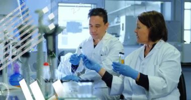 Çeşitli bilim adamları üzerinde finansal veri işleme animasyonu. Küresel bilim, iş, bağlantılar, hesaplama ve veri işleme kavramı dijital olarak oluşturulmuş video.