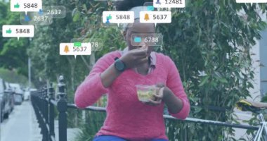 Afro-Amerikan kadınlarının şehir caddesinde yemek yemesi ile ilgili medya bildirimleri. Yaz, sağlıklı yaşam tarzı, şehir, dijital arayüz, sosyal ağ ve iletişim, dijital olarak oluşturulmuş video.