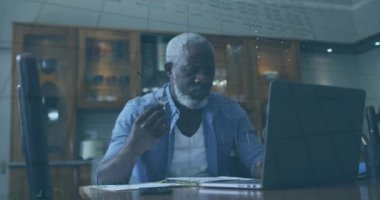 Dizüstü bilgisayar kullanan yaşlı Afro-Amerikan bir adamın finansal veri işleme animasyonu. Küresel finans, iş, bağlantılar, hesaplama ve veri işleme kavramı dijital olarak oluşturulmuş video.
