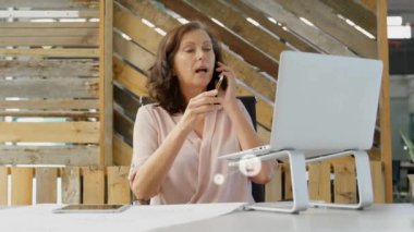Akıllı telefon kullanan Kafkasyalı iş kadını üzerindeki simgelerle bağlantı ağının animasyonu. Küresel finans, iş, bağlantılar, hesaplama ve veri işleme kavramı dijital olarak oluşturulmuş video.