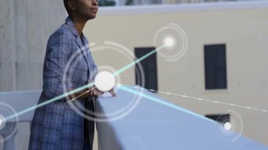 Balkonda dikilen Afro-Amerikan iş kadınının bağlantı ağının animasyonu. Dijital olarak oluşturulmuş küresel bağlantılar, bilgisayar, iş ve dijital arayüz kavramı.