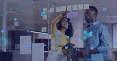 Ofiste beyin fırtınası yapan çeşitli erkek ve kadın meslektaşlar üzerine medya simgelerinin animasyonu. Bağlantı, iş, ağ, takım çalışması ve iletişim, dijital olarak oluşturulmuş video.