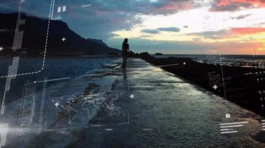 Deniz kenarında yürüyen beyaz kadın hakkında veri işleme ve diyagramların animasyonu. Küresel iş ve dijital arayüz kavramı dijital olarak oluşturulmuş video.