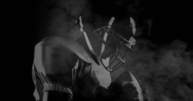 Siyah arka planda sigara içerken Amerikan futbolcusu görüntüsü. global spor konsepti dijital olarak oluşturulmuş görüntü.