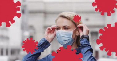 Yüz maskesi takan beyaz bir kadının üzerindeki virüs hücrelerinin animasyonu. Küresel salgın, sağlık, bilim ve dijital arayüz kavramı dijital olarak oluşturulmuş video.