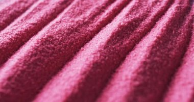 Tırtıklı desenli, desenli pembe bir kumaşın yakın çekimi. Görüntü, materyalin detaylı dokusunu ve canlı rengini gösteriyor..