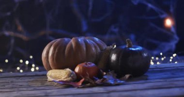 Balkabakları ve mısırlar geceleri tahta bir yüzeyde fotokopi alanı ile dinlenir. Ayar bir sonbahar temasını işaret ediyor, Cadılar Bayramı ya da hasat kutlaması için, yavaş çekim..