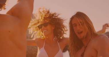 Farklı arkadaş grupları sahilde dans edip eğleniyorlar. Arkadaşlık, seyahat ve tatil konsepti