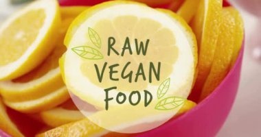 Masadaki portakal dilimleri üzerinde çiğ vejetaryen yemek metni animasyonu. Diyet, sağlıklı yaşam tarzı ve dijital olarak üretilen gıda konsepti.