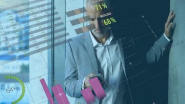 Beyaz iş adamının akıllı telefon kullanarak üzerinde şema ve veri işleme animasyonları. Küresel iş ve dijital arayüz kavramı dijital olarak oluşturulmuş video.