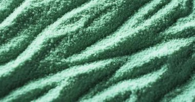 Dalgalı desenli, desenli yeşil bir kumaşa yakın çekim. Resim, materyalin karmaşık detaylarını ve dokusunu gösteriyor, çeşitli kumaşlarda potansiyel kullanımını vurguluyor.