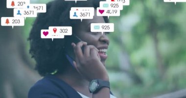 Mutlu Afro-Amerikan kadınlarının akıllı telefondan konuşması üzerine sosyal medya bildirimleri. Dijital arayüz, bağlantı, sosyal ağ, yaşam tarzı ve iletişim, dijital olarak oluşturulmuş video.