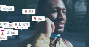 Mutlu Afro-Amerikan bir adamın akıllı telefondan konuşması üzerine sosyal medya bildirimleri. Dijital arayüz, bağlantı, sosyal ağ, yaşam tarzı ve iletişim, dijital olarak oluşturulmuş video.