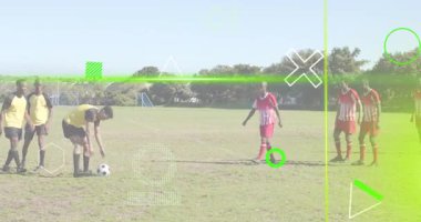 Futbolcu topu konumlandırıyor ve sahada savunma duvarının ötesine dijital kaplamayla vuruyor. Sporcular, müsabakalar, spor, açık hava, takım çalışması, aksiyon, eğlence