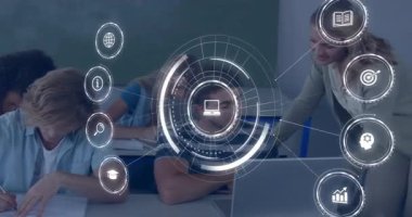 Öğretmenler sınıfta öğrencilere rehberlik ederken dizüstü bilgisayarların etrafında beliren dijital çemberler. Eğitim, e-öğrenim, yenilik, teknoloji, işbirliği, ilham, sınıf