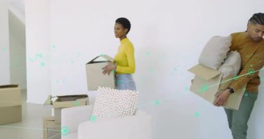 Moving couple starting unpacking boxes in new living room, arranging pillows on sofa for styling. Home, interior, renovation, staging, celebration, casual, cheerful