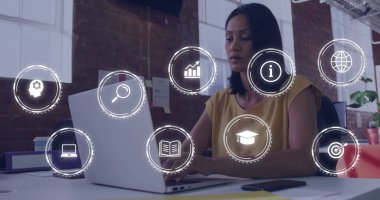 Ofis masasında hardal kapaklı, dizüstü bilgisayarda, dijital simgelerde fotokopi alanını kaplayan olgun bir kadın yazmak. Profesyonel, çalışma alanı, modern, üretkenlik, teknoloji, işbirliği, çağdaş