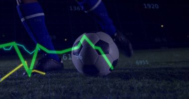 Mavili çoraplı, kramponlu, veri analizli çimenlerin üzerinde tepinmeyi bekleyen bir futbol topu. Atletik, spor, dijital, performans, stadyum, rekabetçi, makine