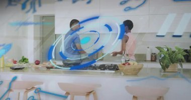 Çift mutfakta yemek hazırlarken adam musluğu açıyor ve mavi grafikleri canlandırıyor. İşbirliği, aşçılık, modernlik, tazelik, sağlık, enerji, yerli