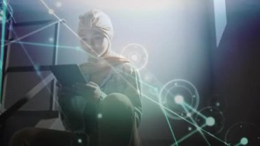 Kadın tableti kucağına yerleştiriyor ve odak etrafında titreşen teknolojik çalışma alanı grafiklerine kayıyor. Gelecekçi, yenilikçi, bağlantı, kentsel, modern, teknoloji, odaklanma