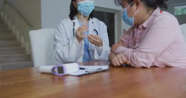 Doktor masadaki termometreyi yerleştiriyor ve şırıngayı iğne yapmak için kaldırırken sağlık örtüsü büyüyor. Tıbbi, sağlık, danışma, klinik, mesleki, tanı, muayene