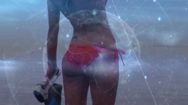 Işıklı dünya animasyonu, plajda elinde tüplü dalış ekipmanıyla bikinili beyaz kadın. Dijital bileşik, çoklu pozlama, dijital arayüz, teknoloji, küresel bilim, refah,