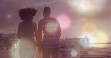 Plajdaki çiftin üzerindeki ışık noktalarının canlandırması. Tatiller ve dijital arayüz kavramı dijital olarak oluşturulmuş video.