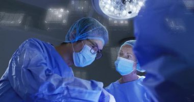 Cerrahi ekip, abdominal kesiği lambanın altında yapıyor. Görüntüleme sistemi, kılavuz dikiş attığını gösteriyor. Tıbbi, takım çalışması, yenilikçi, klinik, kesinlik, işbirliği, teknoloji