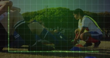 Futbol oyuncusu sarı önlük giyip çimlere krampon bağlıyor, mavi kozalaklı, fotokopi alanı. Atletizm, takım çalışması, fitness, açık hava, antrenman, rekabet, kararlılık