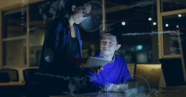 Dizüstü bilgisayarda kot ceket giyen ve geceleri ofiste tablet kullanan iş arkadaşları. Teknoloji, işbirliği, yenilik, veri görselleştirme, takım çalışması, modern, profesyonel