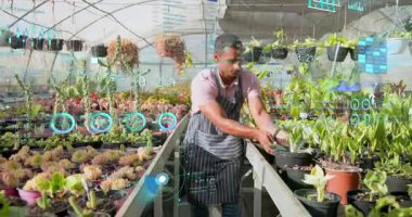 Sera bahçıvanı sulu sulara eğilip bitki sağlığını izlemek için AR çizelgelerini başlatıyor. Botanik, yenilik, dijital, çevre, büyüme, teknoloji, manzara