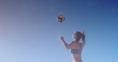 Deniz kenarında plaj voleybolu oynayan beyaz kadının üzerinde parlayan ışıkların canlandırması. Egzersiz, refah, spor, açık hava yaşam tarzı, yaz ve tatil konsepti dijital olarak oluşturulmuş video.