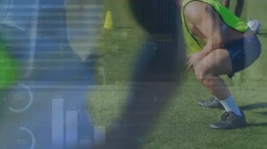 Animation of financial data and graphs over male soccer players on sport field. Sport, training, finance and economy concept digitally generated video.