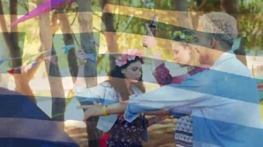 Animation of flag of greece over diverse group of friends having party outdoors. Politics and patriotism concept digitally generated video.