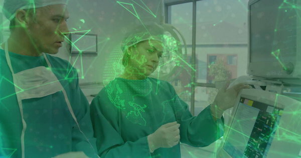 Два хирурга следят за жизненно важными показателями на пульте в операционной, с хирургическими шапками и платьями. Медицина, здравоохранение, технология, клиника, диагностика, командная работа, передовые технологии