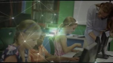 Öğretmen laboratuvara giriyor öğrenci klavyesine yaslanıyor, dijital grafikler zayıflarken kodlamayı yönlendiriyor. Sınıf arkadaşları, eğitim, teknoloji, öğrenme, sınıf, takım çalışması, akıl hocalığı