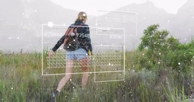 Dişi yürüyüşçü sisli çayırlara giriyor ve hareket analizi yapan veri görselleştirme panellerini çalıştırıyor. Macera, keşif, teknoloji, vahşi doğa, doğa, veri görselleştirme, açık hava