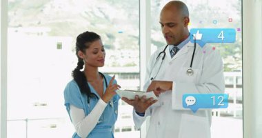 Hemşire tıkırtısı tablet ekranı içeriği gözden geçiriyor ve tıbbi ekibin etrafında nişan ikonları oluşturuyor. İşbirliği, teletıp, sağlık, dijital etkileşim, profesyonel takım çalışması, modern sağlık, kentsel ufuk çizgisi